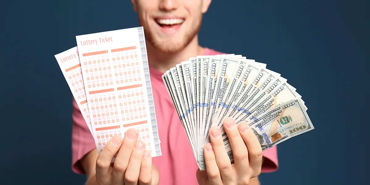 Glücklicher Mann mit Lottotickets und Geld in den Händen