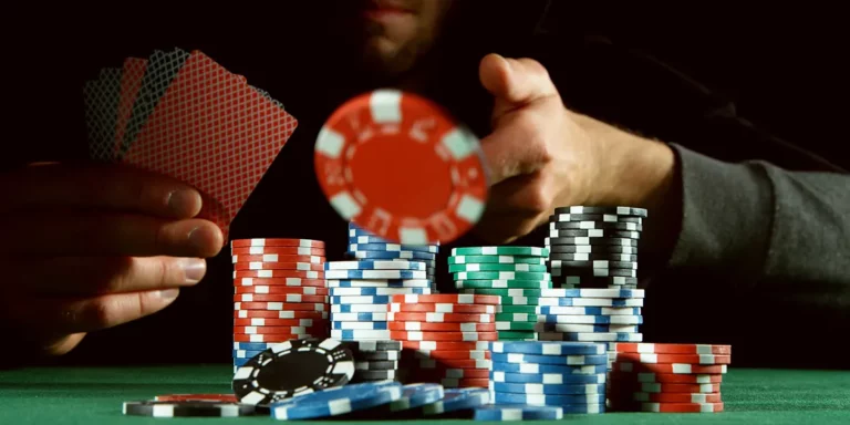 Mann wirft Poker-Chip auf Tisch mit Stapeln von Poker-Chips
