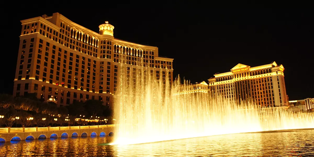 Außenansicht des beleuchteten Bellagio Casinos in Las Vegas mit Wasserfontänen bei Nacht