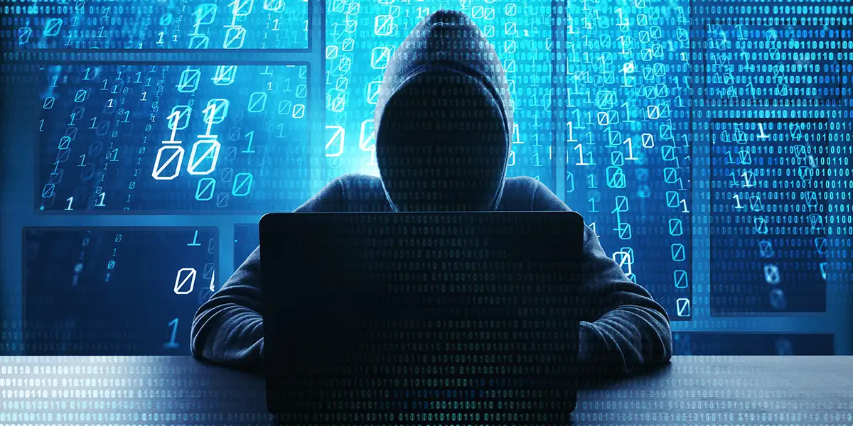Vermummter Hacker vor Laptop