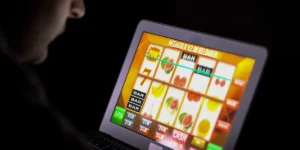 Mann spielt Slot Machine an seinem Laptop