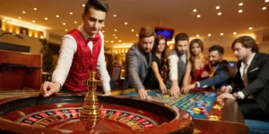 Roulette Tisch mit Croupier und mehreren Spielern beim Setzen