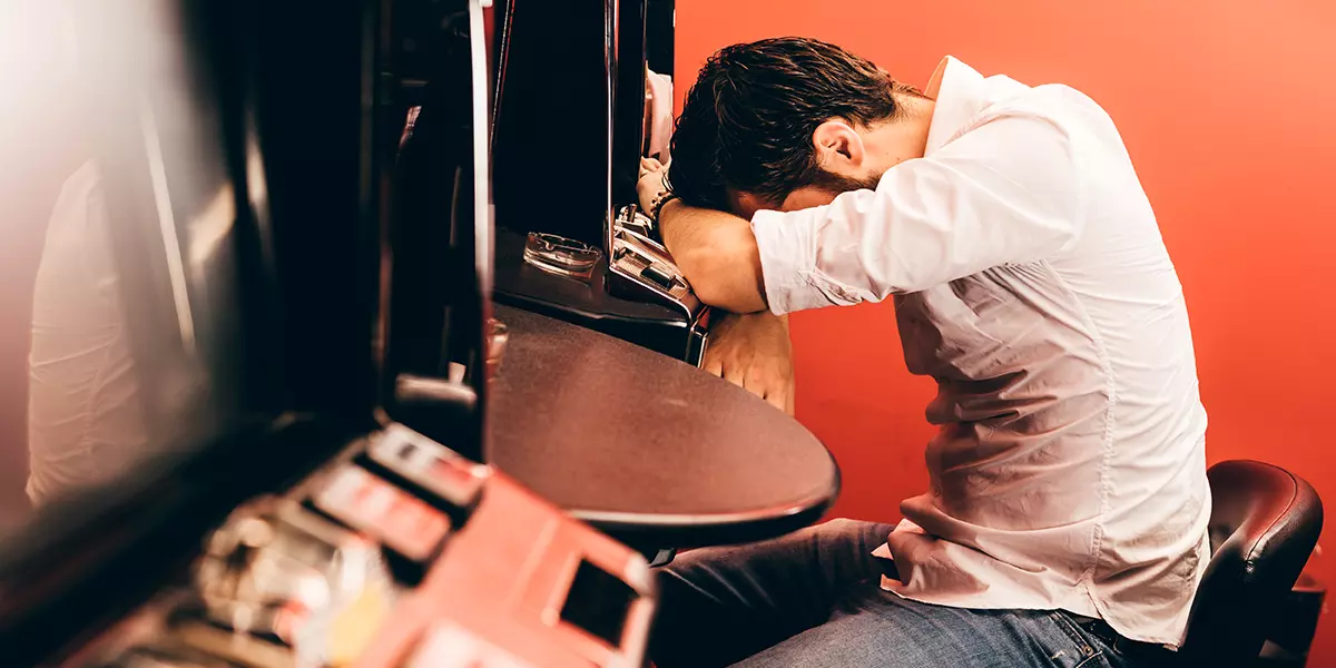 Frustrierter Mann beim Verlieren am Spielautomat