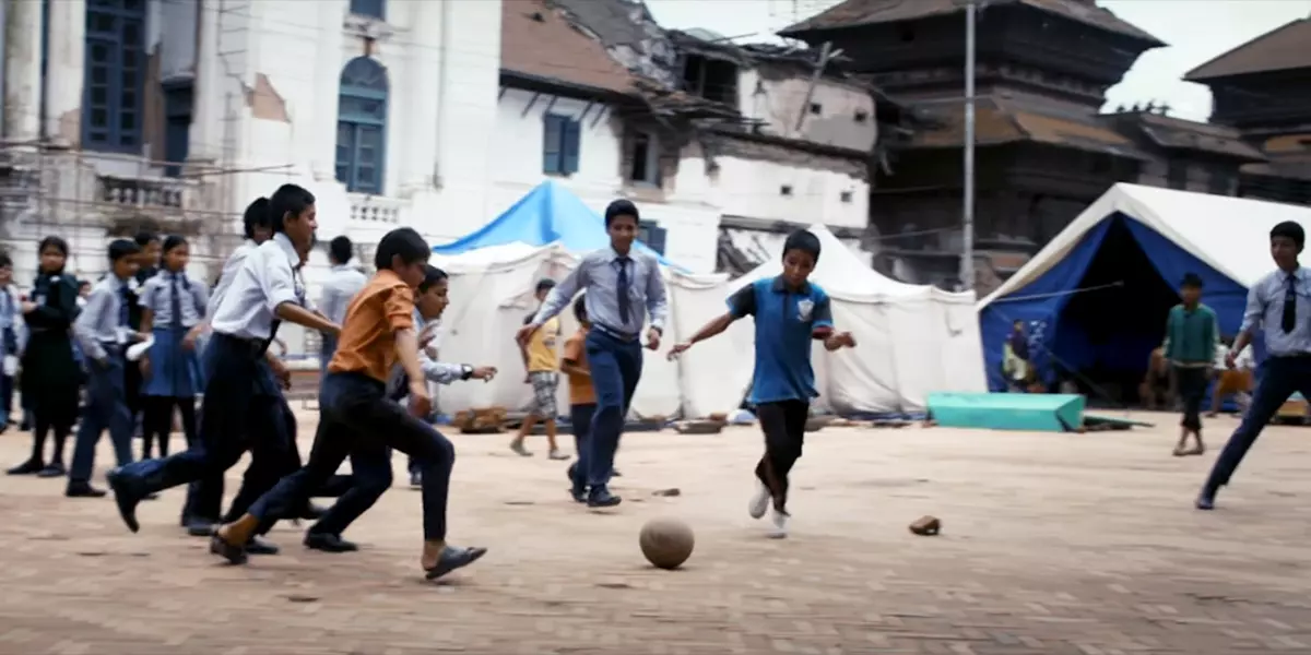 Kinder spielen Fußball in ärmlicher Stadt