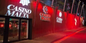 Das rot beleuchtete Casino Malta von außen bei Nacht