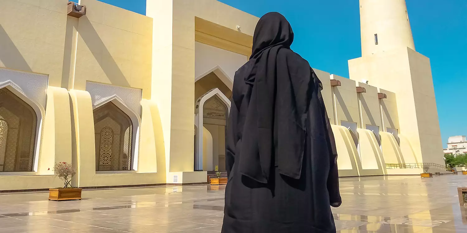 Verschleierte Frau von hinten vor Moschee