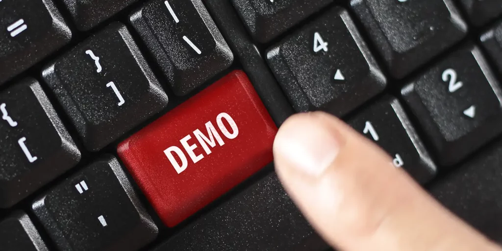 Finger tippt auf rote Tastatur-Taste mit Aufschrift "Demo"