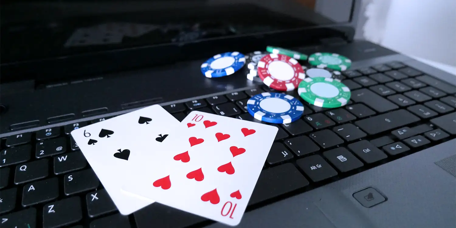 Pokerkarten und Pokerchips auf Laptop-Tastatur