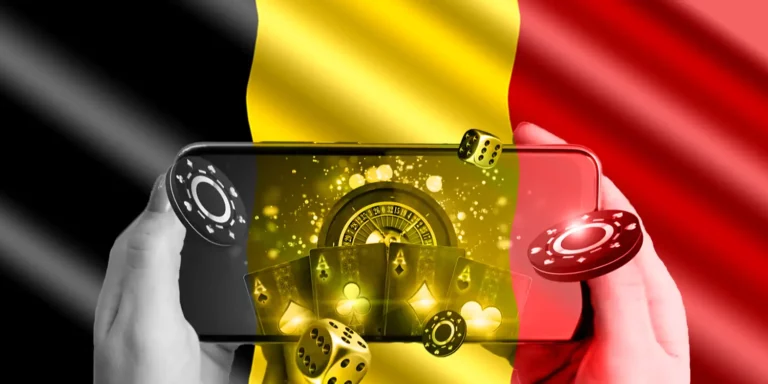 Smartphone mit Online-Glücksspiel auf dem Display vor Belgischer Flagge im Hintergrund