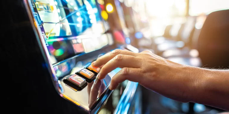 Hand eines Spielers bedient Spielautomat