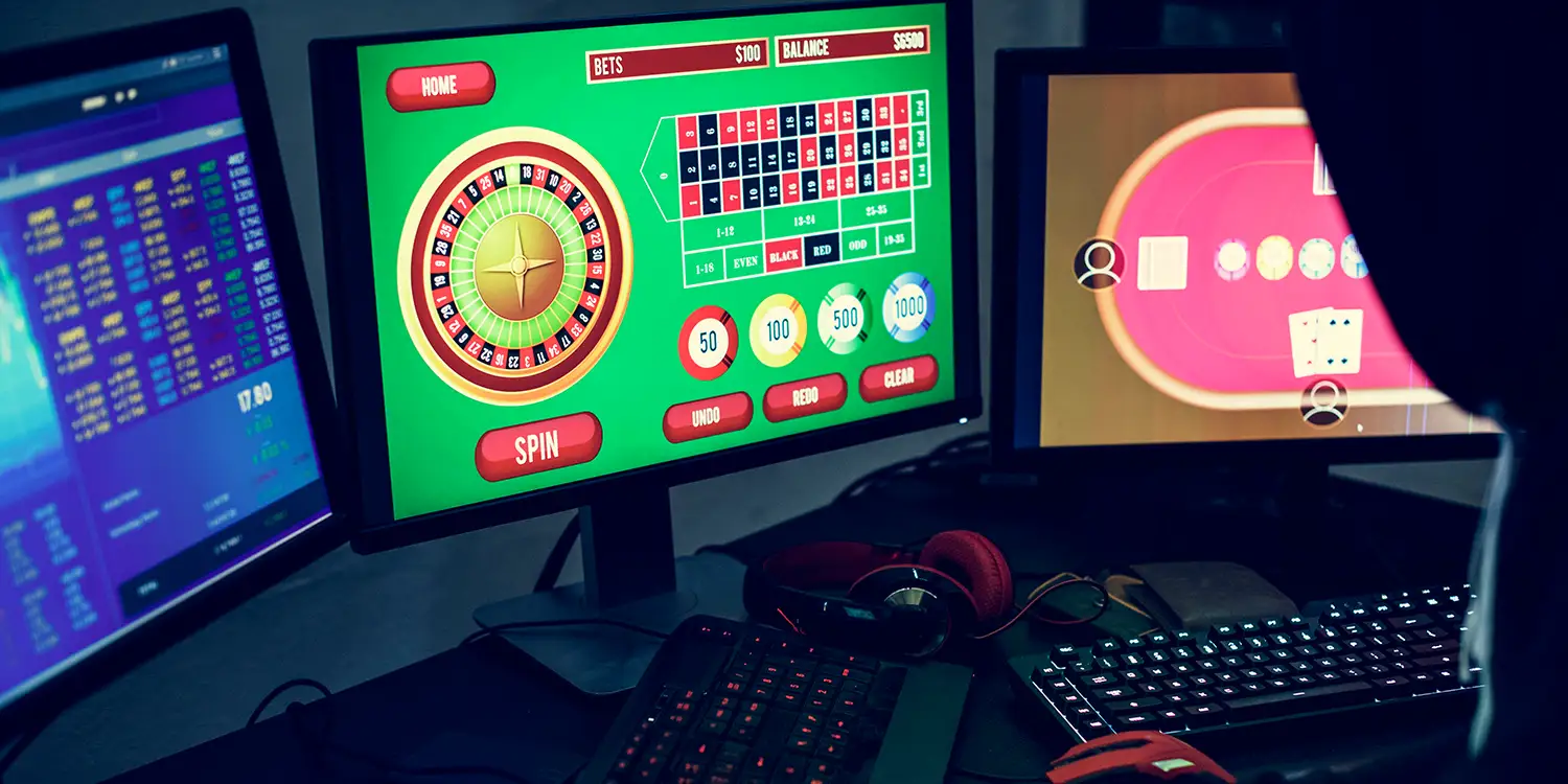 Person mit Hoody spielt illegale Online-Glücksspiele am PC