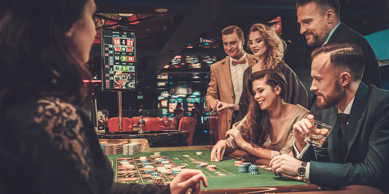Spieler am Roulette-Tisch und im Hintergrund Anzeige der Permanenzen