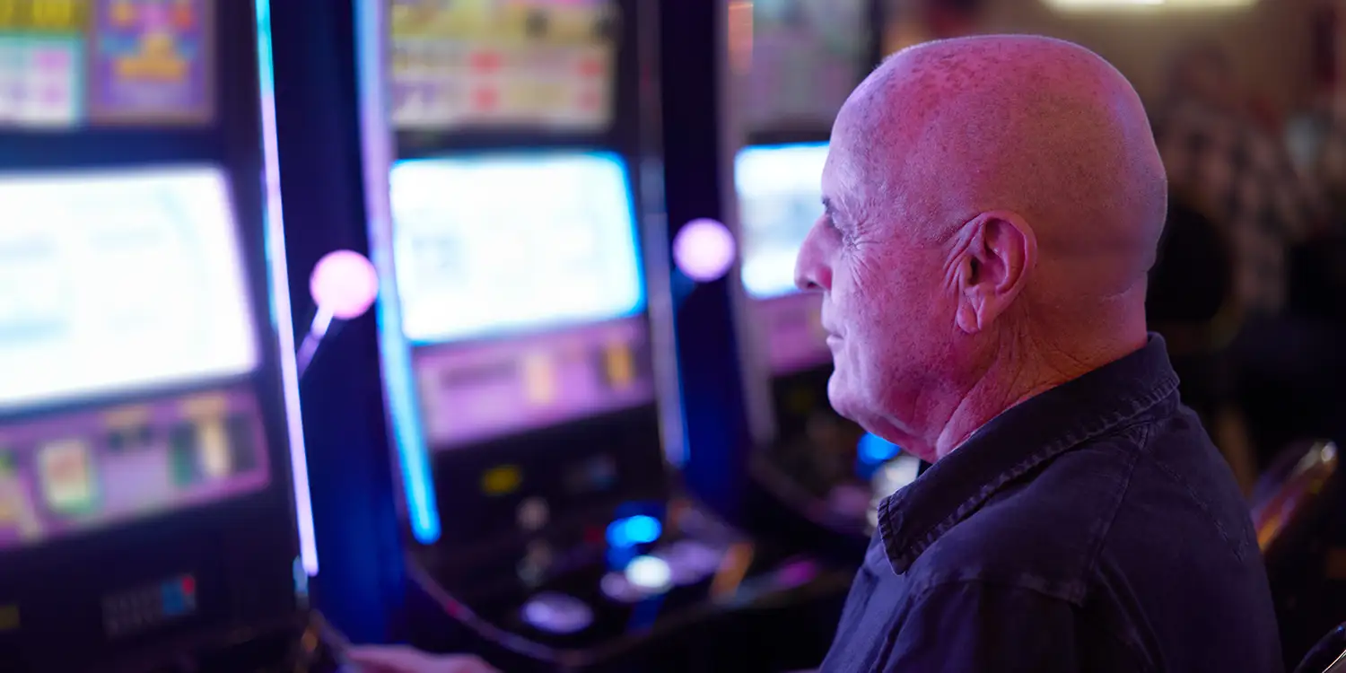 Älterer Herr spielt an einem Spielautomaten