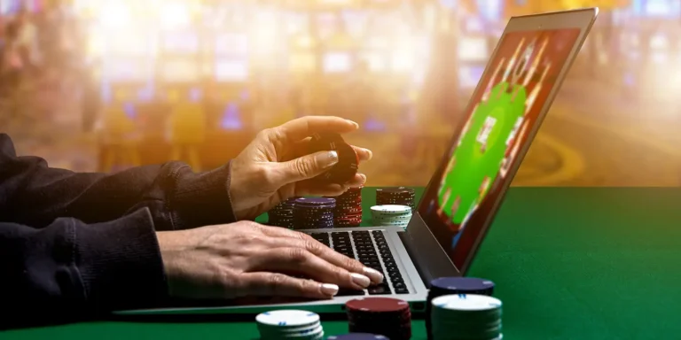 Spielerin spielt Poker am Laptop mit Spielautomaten im Hintergrund