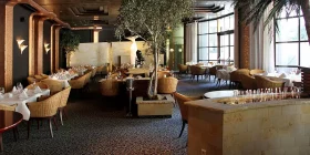 Tische mit Rattan-Stühlen im elegant eingedeckten Restaurant