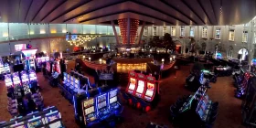 Großer Saal mit vielen Spielautomaten und einer Bar in der Mitte