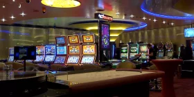 Roulette-Tisch und Spielautomaten im Hintergrund