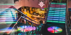 Bunt beleuchtete Treppe im Casino Helsinki mit Blick auf Sports Bar