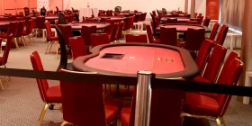 Großer Raum mit sehr vielen roten Pokertischen