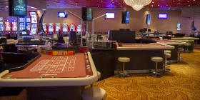Großer Raum mit Spielautomaten und Roulette-Tischen