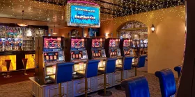 Raum mit mehreren Spielautomaten und Bar im Hintergrund