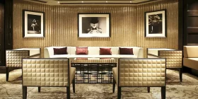 Eleganter Lounge-Bereich mit Couch, Sesseln und Bildern an der Wand