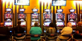 6 Spielautomaten mit Spielern von hinten