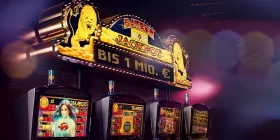 4 Spielautomaten nebeneinander mit Leuchtschild darüber und Schriftzug "Bayern Jackpot - Bis 1 Mio. EUR"