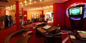 Großer Raum mit rotem Teppich und Roulette-Terminals sowie diversen Spielautomaten