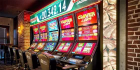 5 Spielautomaten nebeneinander mit Anzeige des aktuellen Standes des Grand Jackpots darüber