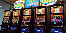 5 Spielautomaten mit Anzeigetafel darüber, die den Stand des Niedersachsen-Jackpots zeigt